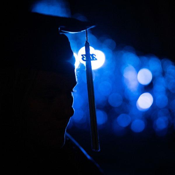 戴着帽子和长袍的人被蓝色的灯照亮.