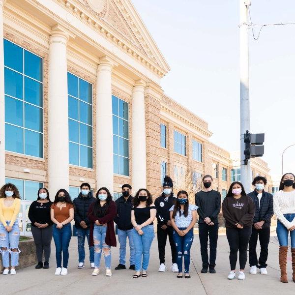 group of high school students standing in row, masked, outside Battle Creek Central High School